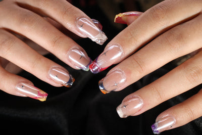 Close-up of hands with decorative nail art on a dark background